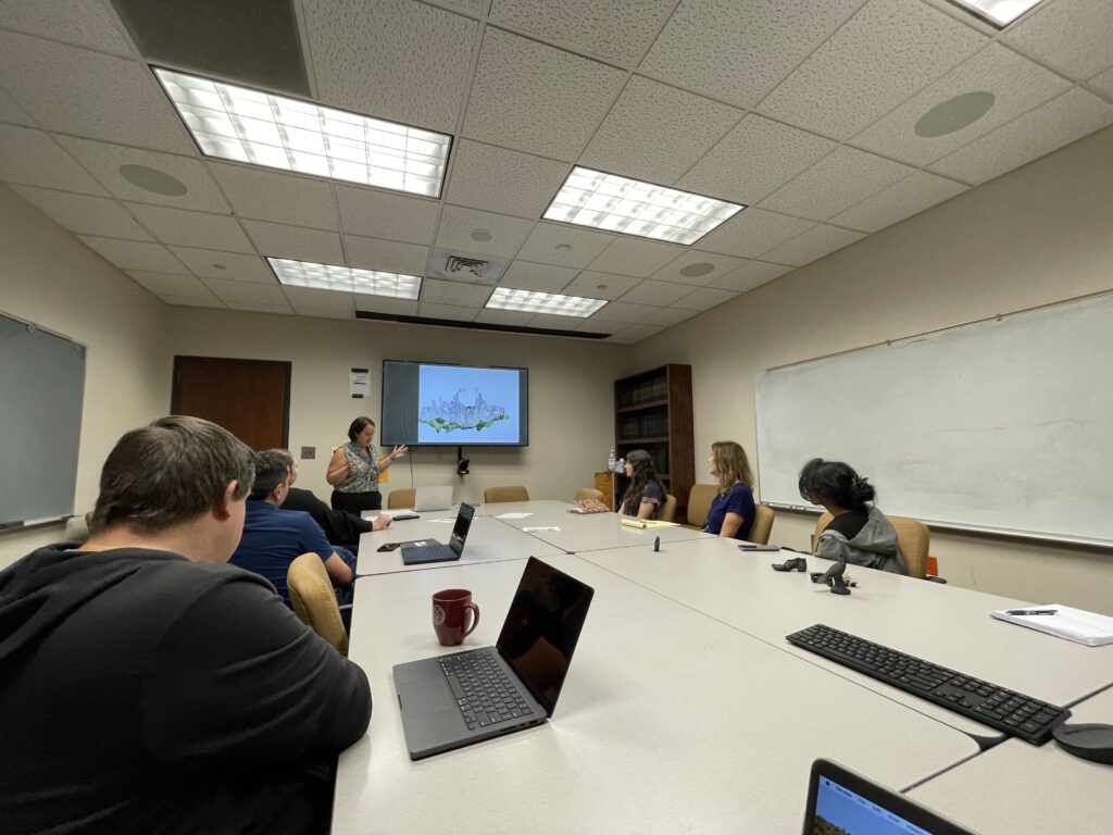 IMG_2535 people seated around a white table in a beige seminar room